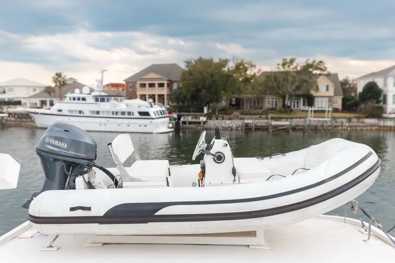Masterplan Yacht Photos Pics Inflatable boat with Yamaha motor on 1975 Hatteras 58 Long Range Cruiser, docked near waterfront homes.