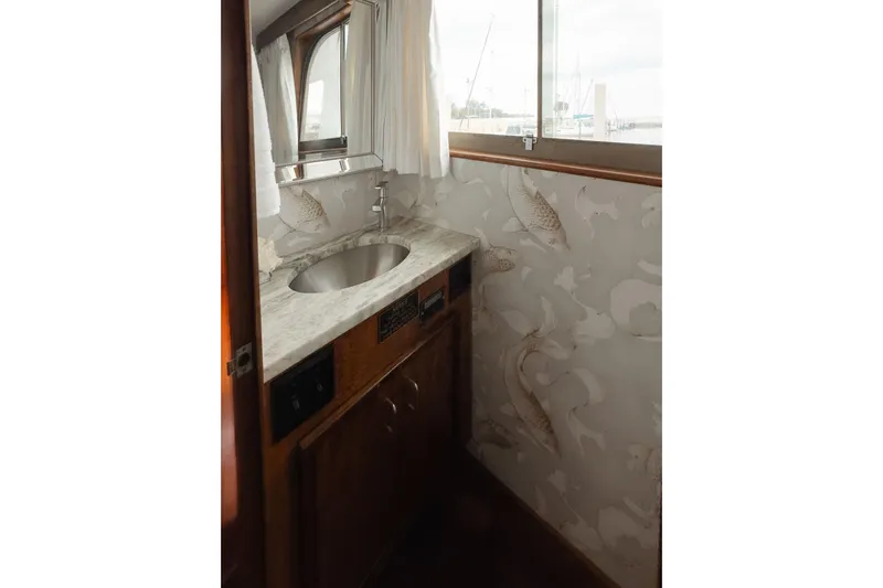 Masterplan Yacht Photos Pics 1975 Hatteras 58 Long Range Cruiser bathroom with marble sink and nautical wallpaper.