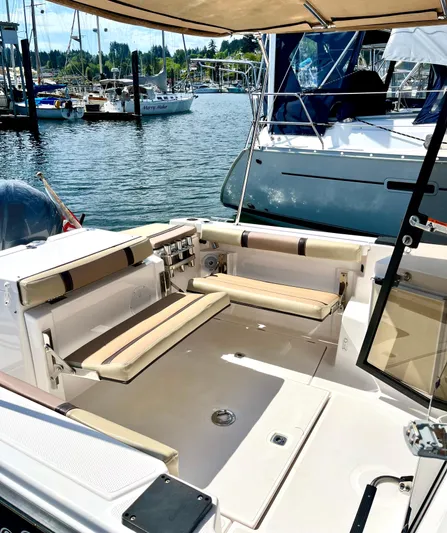  Yacht Photos Pics 2018 Ranger Tugs R-27 boat interior at marina, featuring seating and open deck.