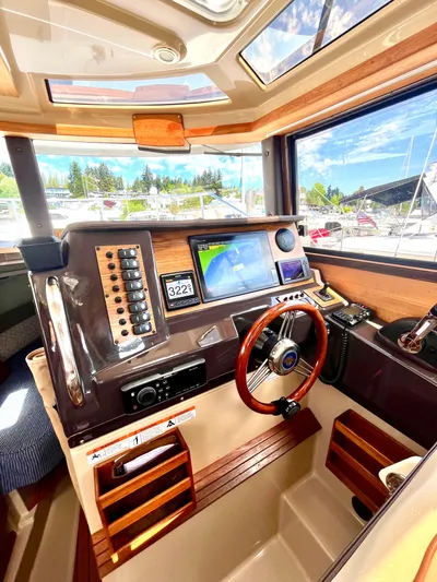  Yacht Photos Pics Interior of 2018 Ranger Tugs R-27 boat with modern navigation equipment and wooden steering wheel.