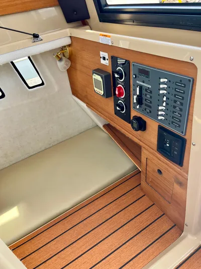  Yacht Photos Pics 2018 Ranger Tugs R-27 cabin interior with control panel and wood accents.
