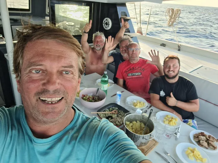 Orange Yacht Photos Pics Group enjoying a meal on a Luna 47 boat, 2023, with ocean view.