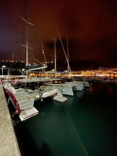 Orange Yacht Photos Pics Boats docked at night in a marina, city lights glowing in the background.