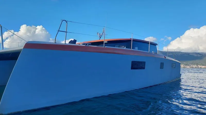 Orange Yacht Photos Pics Modern Luna 47 catamaran sailing on clear blue waters, 2023 model.