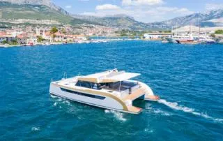Orange Yacht Photos Pics Modern Luna 47 catamaran sailing in scenic coastal waters, 2023 model.