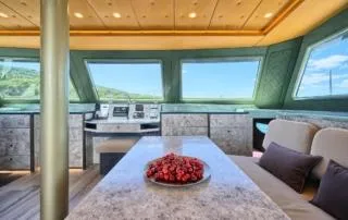 Orange Yacht Photos Pics Luxurious interior of 2023 Luna 47 yacht with panoramic windows and elegant seating.