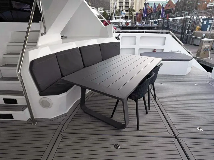 Pilar X Yacht Photos Pics Outdoor seating area on 2024 Leeuwin 55 yacht with modern table and cushions.