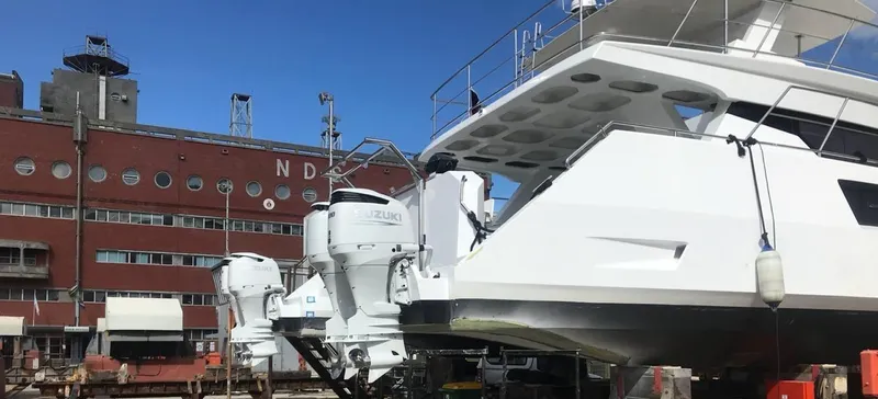 Pilar X Yacht Photos Pics 2024 Leeuwin 55 yacht with Suzuki engines docked near industrial building.