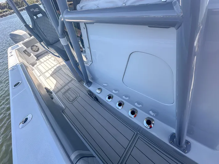  Yacht Photos Pics 2021 SeaVee 370z boat deck with rod holders and seating, docked by the water.