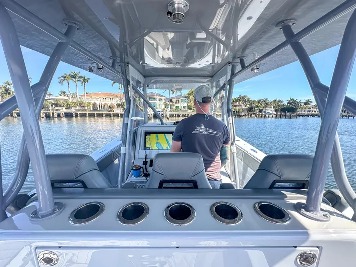  Yacht Photos Pics 2021 SeaVee 370z boat interior with person navigating on calm water.