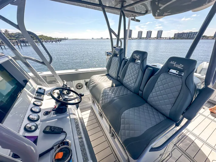  Yacht Photos Pics 2021 SeaVee 370z boat interior with luxury seating and control panel, overlooking a scenic waterfront.