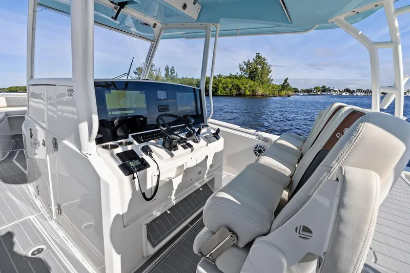 No Name Yacht Photos Pics 2023 Cobia 350 Center Console boat interior with helm and seating, on a scenic waterway.