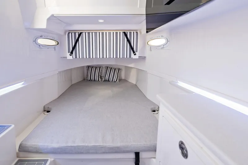 No Name Yacht Photos Pics 2023 Cobia 350 Center Console cabin interior with bed and striped pillows.