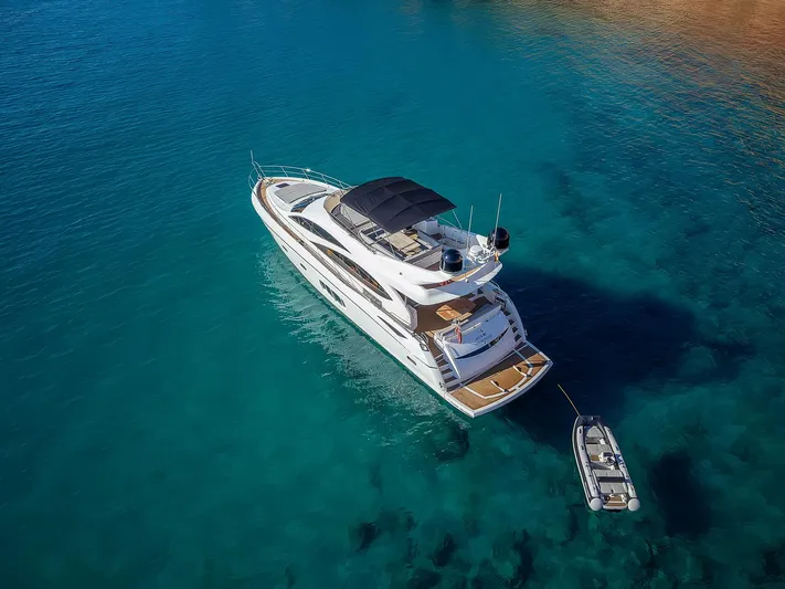  Yacht Photos Pics Sunseeker Manhattan 70 yacht, 2008 model, anchored in clear blue water with a small boat.