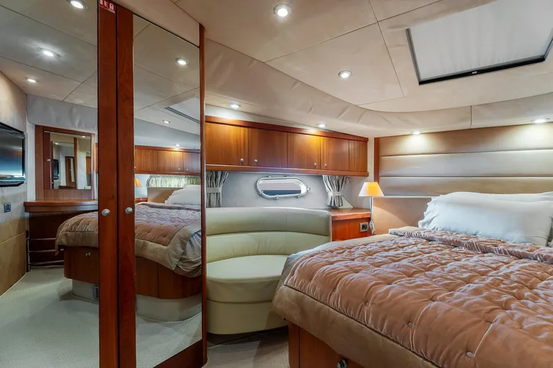  Yacht Photos Pics Luxurious 2008 Sunseeker Manhattan 70 yacht bedroom with elegant wood finishes and cozy lighting.