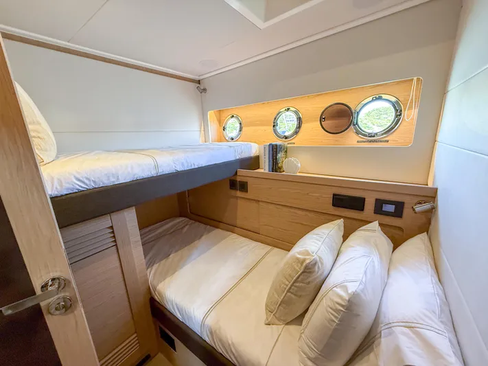 In Stock Yacht Photos Pics 2026 Beneteau Swift Trawler 54 cabin with bunk beds and porthole windows.