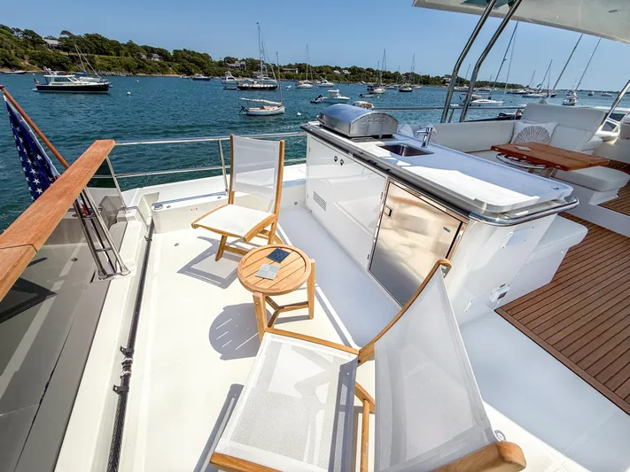 In Stock Yacht Photos Pics Deck of 2026 Beneteau Swift Trawler 54 with seating and outdoor kitchen, overlooking marina.