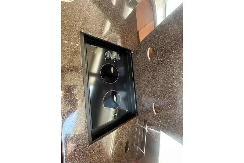 Havadk Yacht Photos Pics 2010 Meridian 391 Sedan kitchen with sleek black cooktop on speckled countertop.