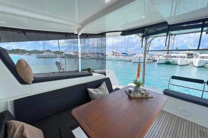 Lucky Vibes Yacht Photos Pics 2018 Lagoon 42 catamaran interior with seating, table, and marina view.
