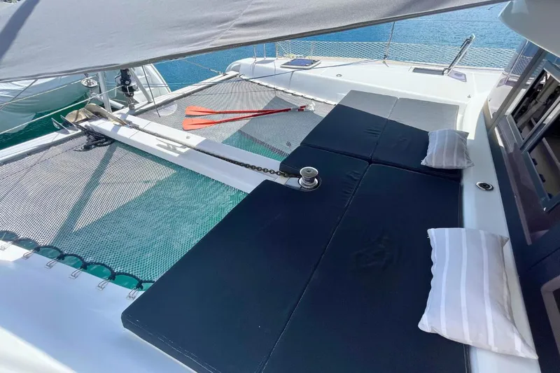 Lucky Vibes Yacht Photos Pics 2018 Lagoon 42 catamaran deck with sunbathing area and netting over water.