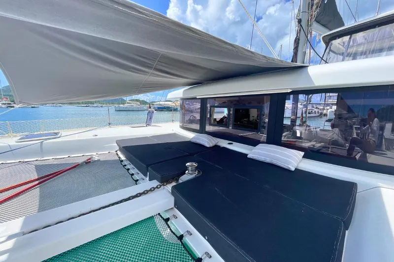 Lucky Vibes Yacht Photos Pics 2018 Lagoon 42 catamaran deck with sunshade and cushions, docked at marina.