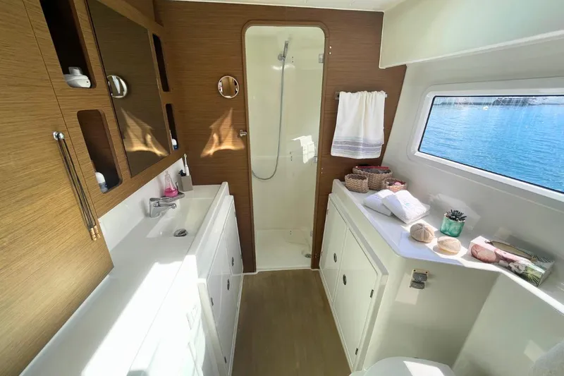 Lucky Vibes Yacht Photos Pics Luxurious bathroom interior of 2018 Lagoon 42 yacht with ocean view window.