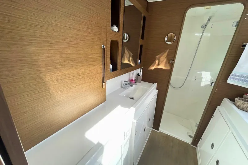 Lucky Vibes Yacht Photos Pics Luxurious bathroom in 2018 Lagoon 42 yacht with modern fixtures and wooden accents.