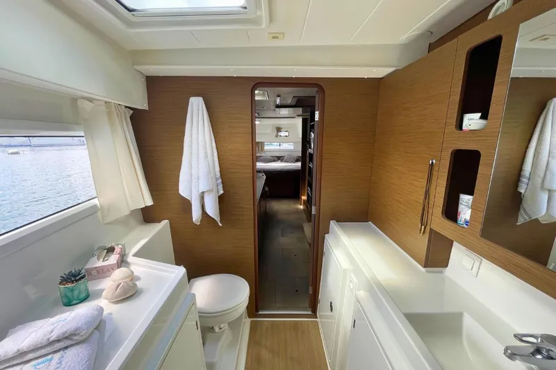 Lucky Vibes Yacht Photos Pics Interior of 2018 Lagoon 42 yacht bathroom with wooden accents and ocean view.