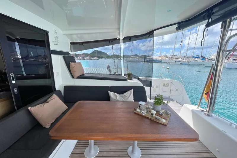 Lucky Vibes Yacht Photos Pics Luxurious 2018 Lagoon 42 catamaran with elegant outdoor seating and scenic marina view.