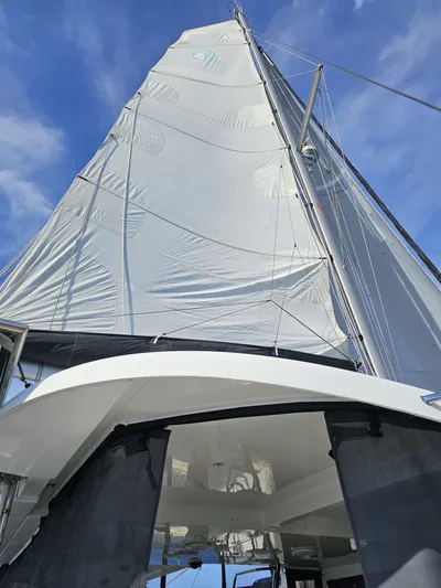 Lucky Vibes Yacht Photos Pics Sailing yacht Lagoon 42, 2018 model, with sails unfurled against a blue sky.