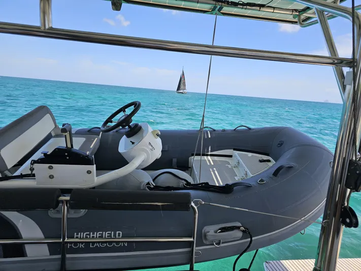 Lucky Vibes Yacht Photos Pics Highfield inflatable boat on Lagoon 42 catamaran, 2018, with ocean view and distant sailboat.
