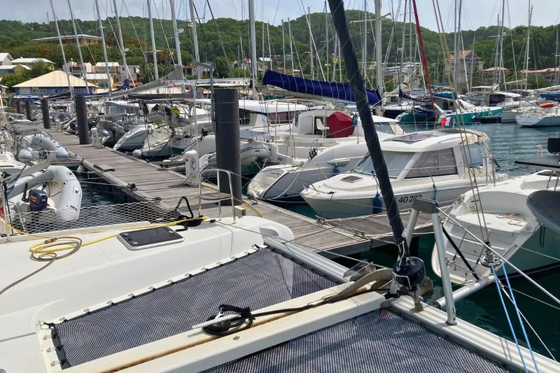 Lucky Vibes Yacht Photos Pics Marina with various boats, including a 2018 Lagoon 42 catamaran, docked under a clear sky.