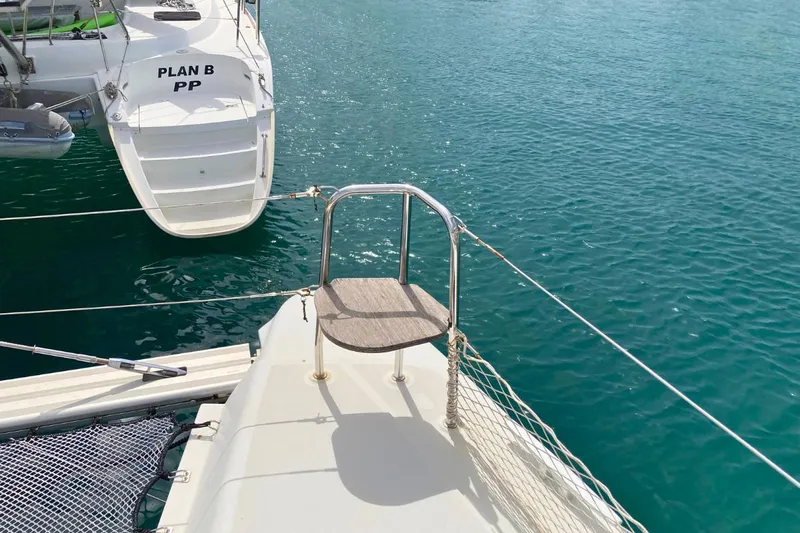 Lucky Vibes Yacht Photos Pics 2018 Lagoon 42 catamaran docked on clear blue water, featuring a rear boarding platform.