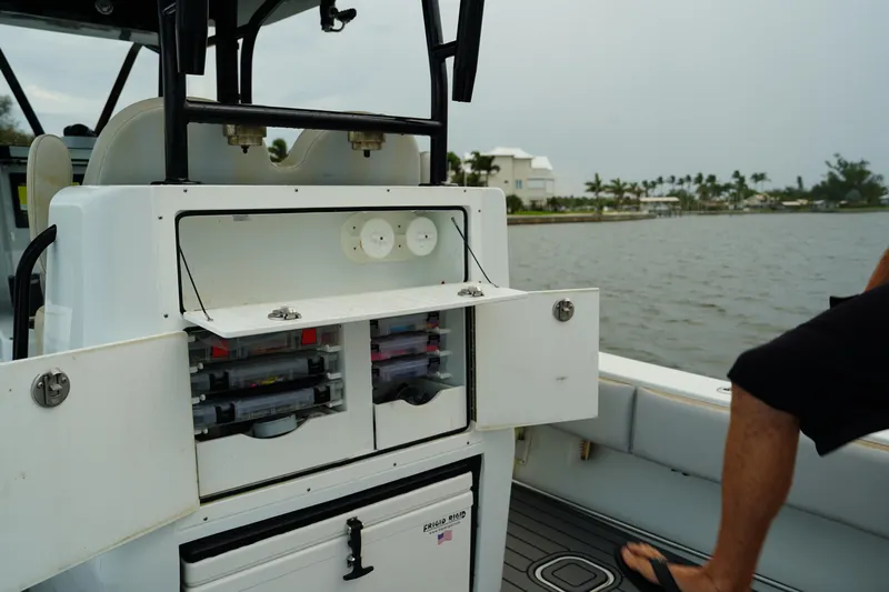  Yacht Photos Pics 2023 Andros 32 Offshore boat with open storage compartments on a calm waterway.