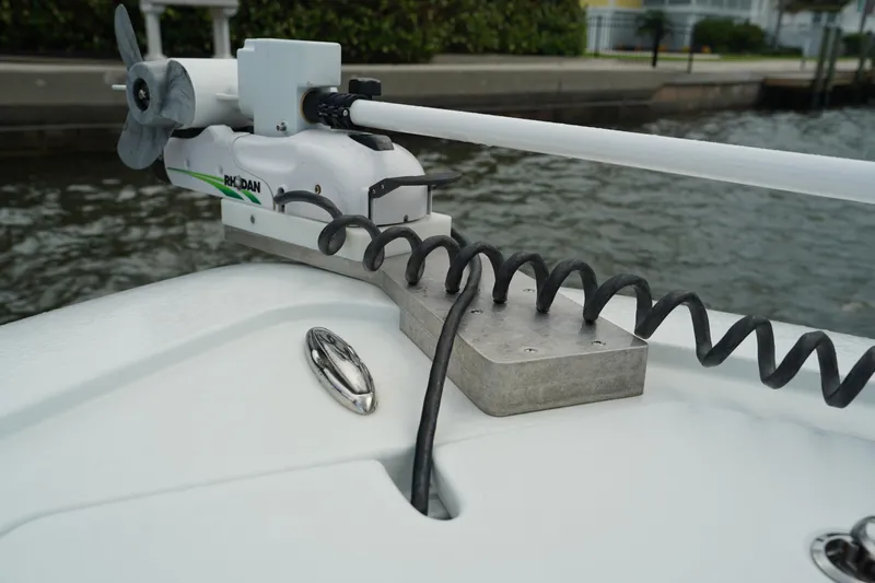  Yacht Photos Pics 2023 Andros 32 Offshore boat with mounted trolling motor by the water.