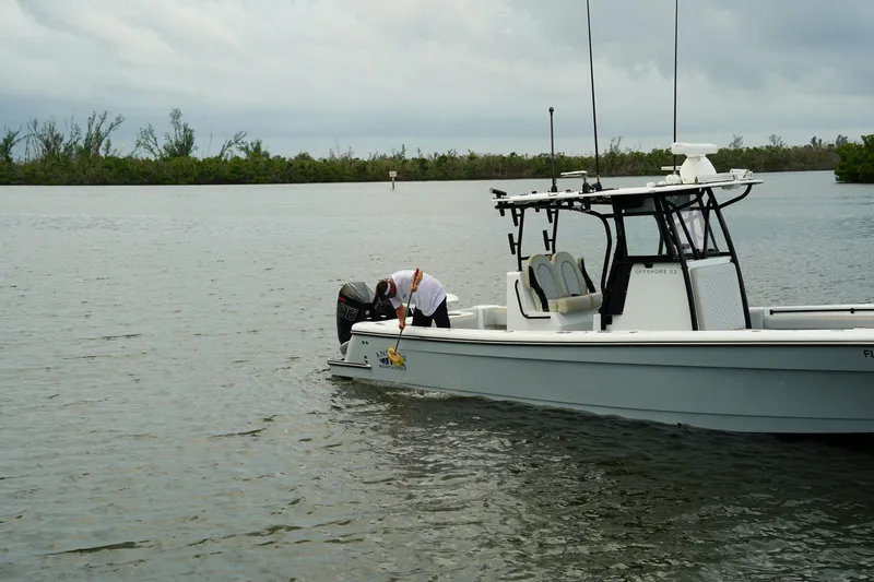  Yacht Photos Pics 2023 Andros 32 Offshore boat on calm water with person adjusting motor.
