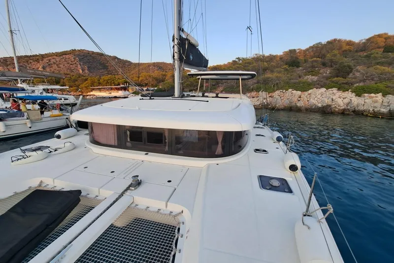  Yacht Photos Pics 2020 Lagoon 42 catamaran docked in scenic coastal marina setting.