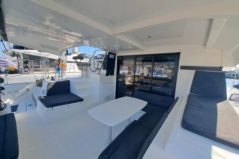  Yacht Photos Pics 2020 Lagoon 42 catamaran interior with seating area and helm station.