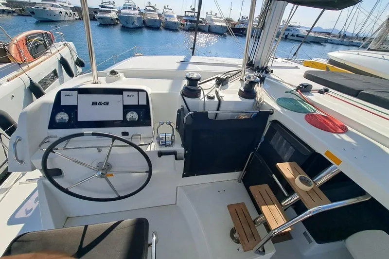  Yacht Photos Pics Cockpit of 2020 Lagoon 42 catamaran with steering wheel and navigation equipment, docked at marina.