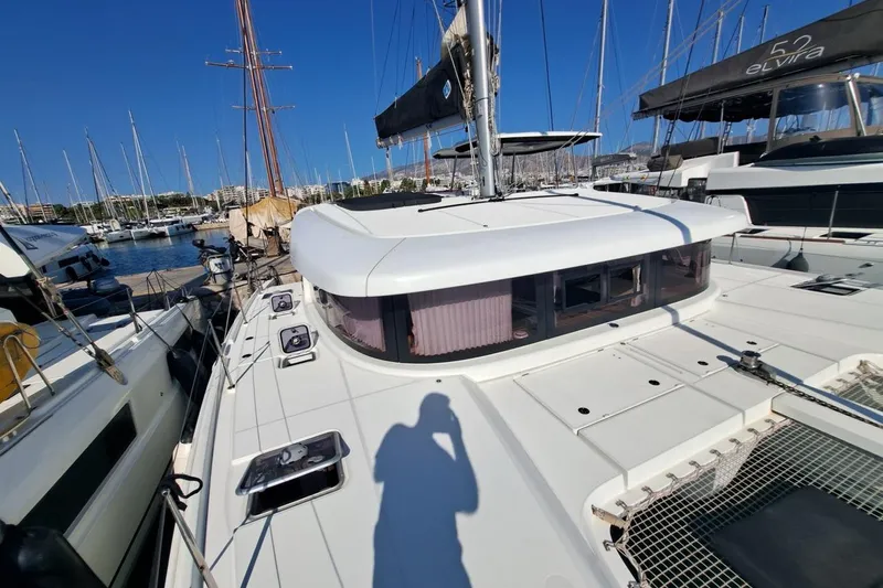  Yacht Photos Pics 2020 Lagoon 42 catamaran docked at marina, clear blue sky, modern design.