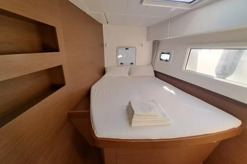  Yacht Photos Pics Luxurious cabin interior of 2020 Lagoon 42 catamaran with cozy bed and windows.