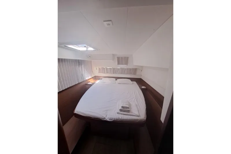  Yacht Photos Pics Cozy bedroom interior of 2020 Lagoon 42 catamaran with skylight and neatly made bed.