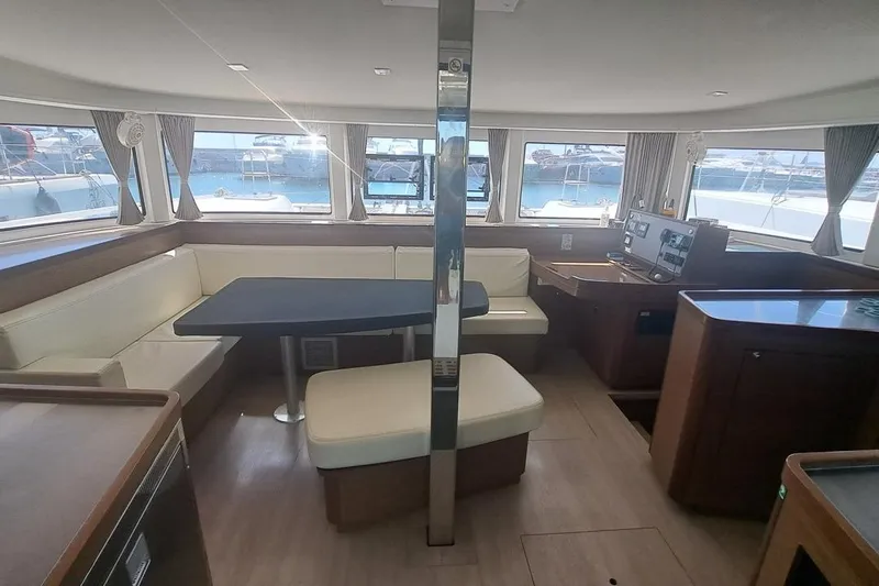  Yacht Photos Pics Interior of 2020 Lagoon 42 catamaran with seating area and navigation station.