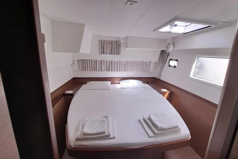  Yacht Photos Pics Luxurious cabin interior of 2020 Lagoon 42 catamaran with cozy bed and natural light.