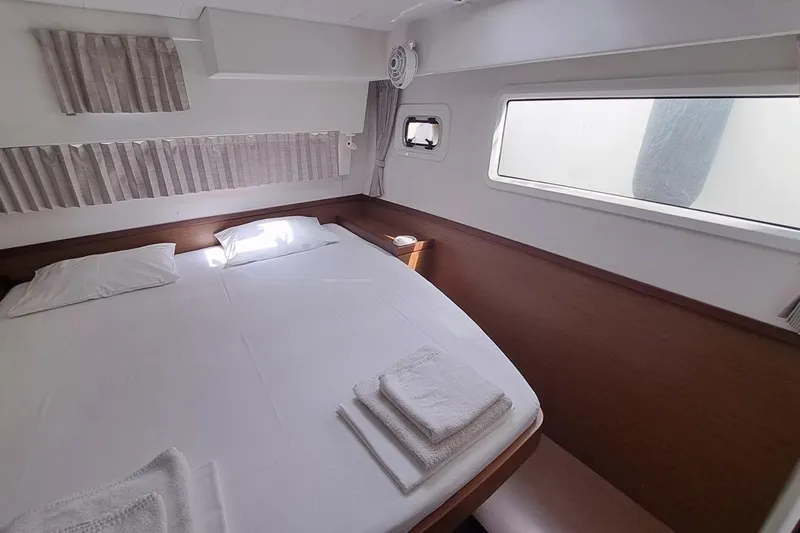  Yacht Photos Pics Cozy cabin interior of 2020 Lagoon 42 catamaran with bed and window view.