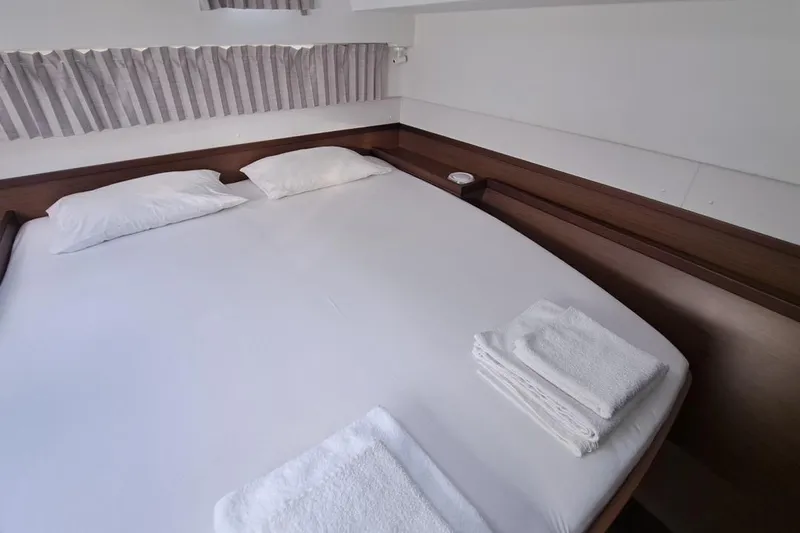  Yacht Photos Pics Cozy cabin interior of 2020 Lagoon 42 catamaran with neatly arranged bed and towels.