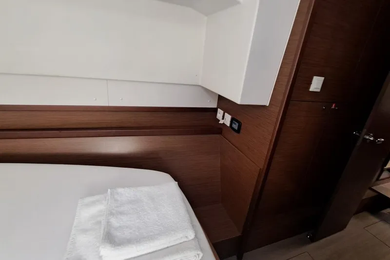  Yacht Photos Pics Interior cabin of 2020 Lagoon 42 yacht with wooden paneling and neatly folded towels.