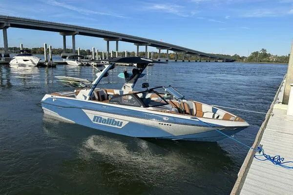  Yacht Photos Pics 2023 Malibu Wakesetter 23 LSV boat docked on a sunny day by a bridge.