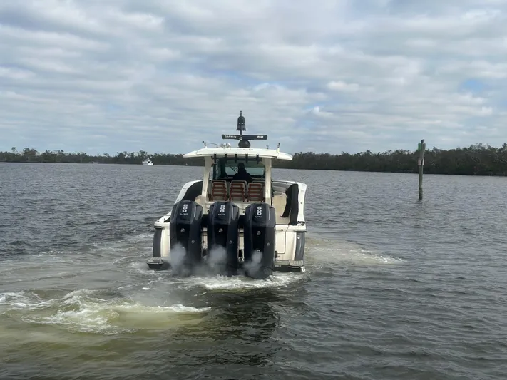  Yacht Photos Pics 2023 Scout 425 LXF boat with multiple engines on a calm waterway.