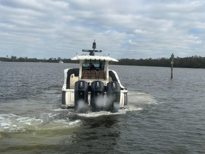  Yacht Photos Pics 2023 Scout 425 LXF boat with four engines cruising on a lake.
